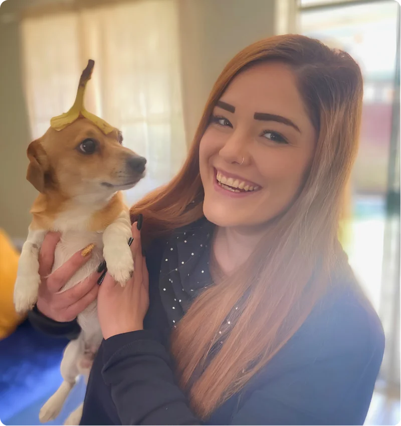 Milica holding her dog with a banana peel balanced on its head